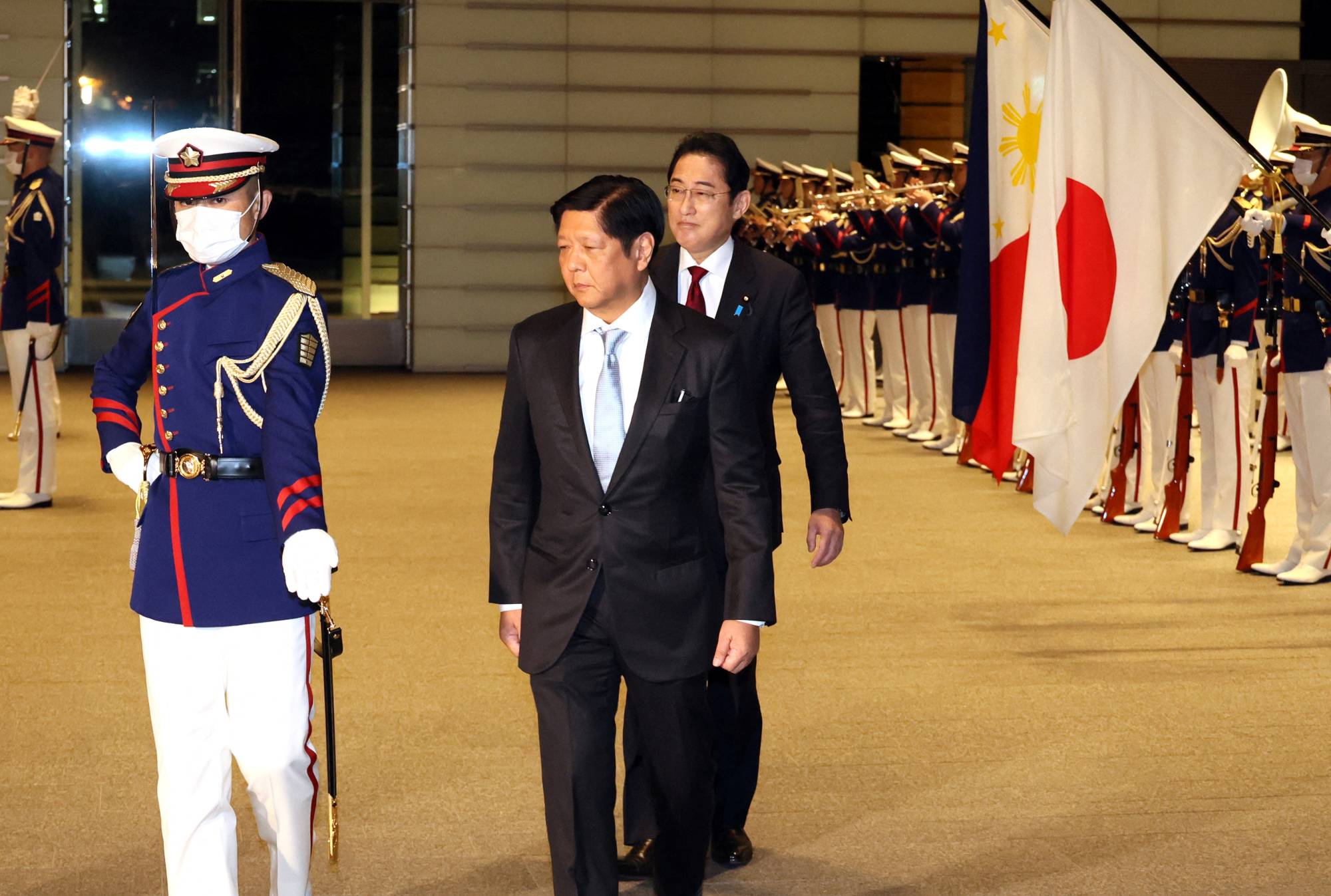 Prime Minister Fumio Kishida and Philippine President Ferdinand Marcos Jr. review an honor guard at the Prime Minister's Official Residence in Tokyo on Feb. 9. | POOL VIA REUTERS