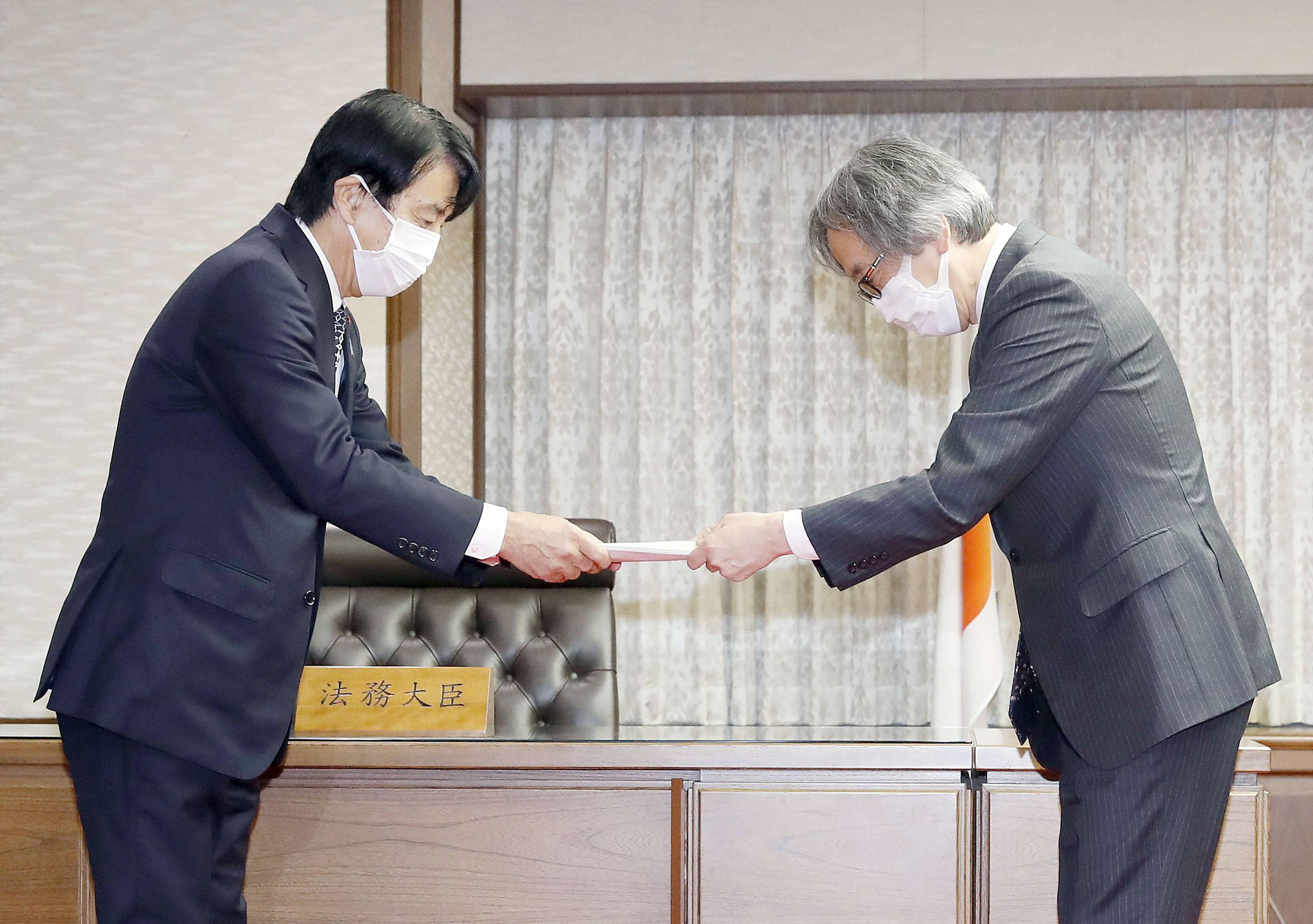 Justice Minister Ken Saito (left) receives proposals from a panel for a major overhaul of sex crime legislation at the ministry on Friday. | KYODO