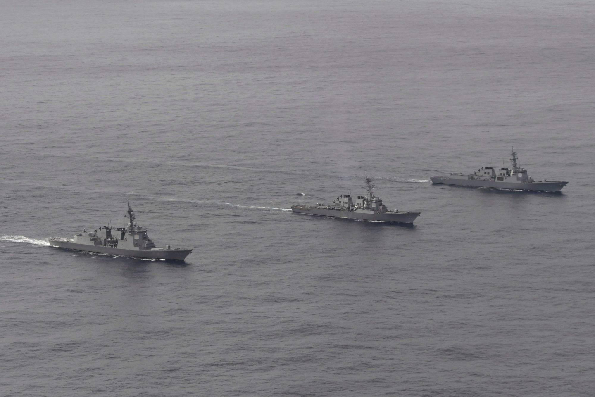 The Maritime Self-Defense Force destroyer Atago (left), U.S. Navy destroyer USS Barry (center) and the South Korean Navy destroyer Sejong Daewang take part in a trilateral exercise in the Sea of Japan on Wednesday. | JAPANESE MINISTRY OF DEFENSE / VIA AFP-JIJI