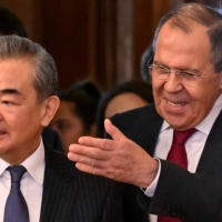China\'s top diplomat, Wang Yi, and Russian Foreign Minister Sergey Lavrov enter a hall during a meeting in Moscow on Wednesday. | POOL / VIA REUTERS