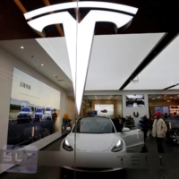 Visitors check peruse a Tesla showroom in Beijing on Feb. 4. | REUTERS