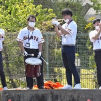 Giants fans play instruments during a spring training game between the Giants and Swallows in Urasoe, Okinawa, on Thursday. | KYODO