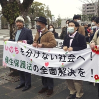 Supporters of a plaintiff of a lawsuit concerning forced sterilization gather in the city of Shizuoka prior to the court\'s handing down of a ruling on Friday. | KYODO