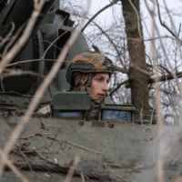 A Ukrainian serviceman sits inside a self-propelled howitzer near the front-line town of Bakhmut, Ukraine, on Saturday.  | REUTERS