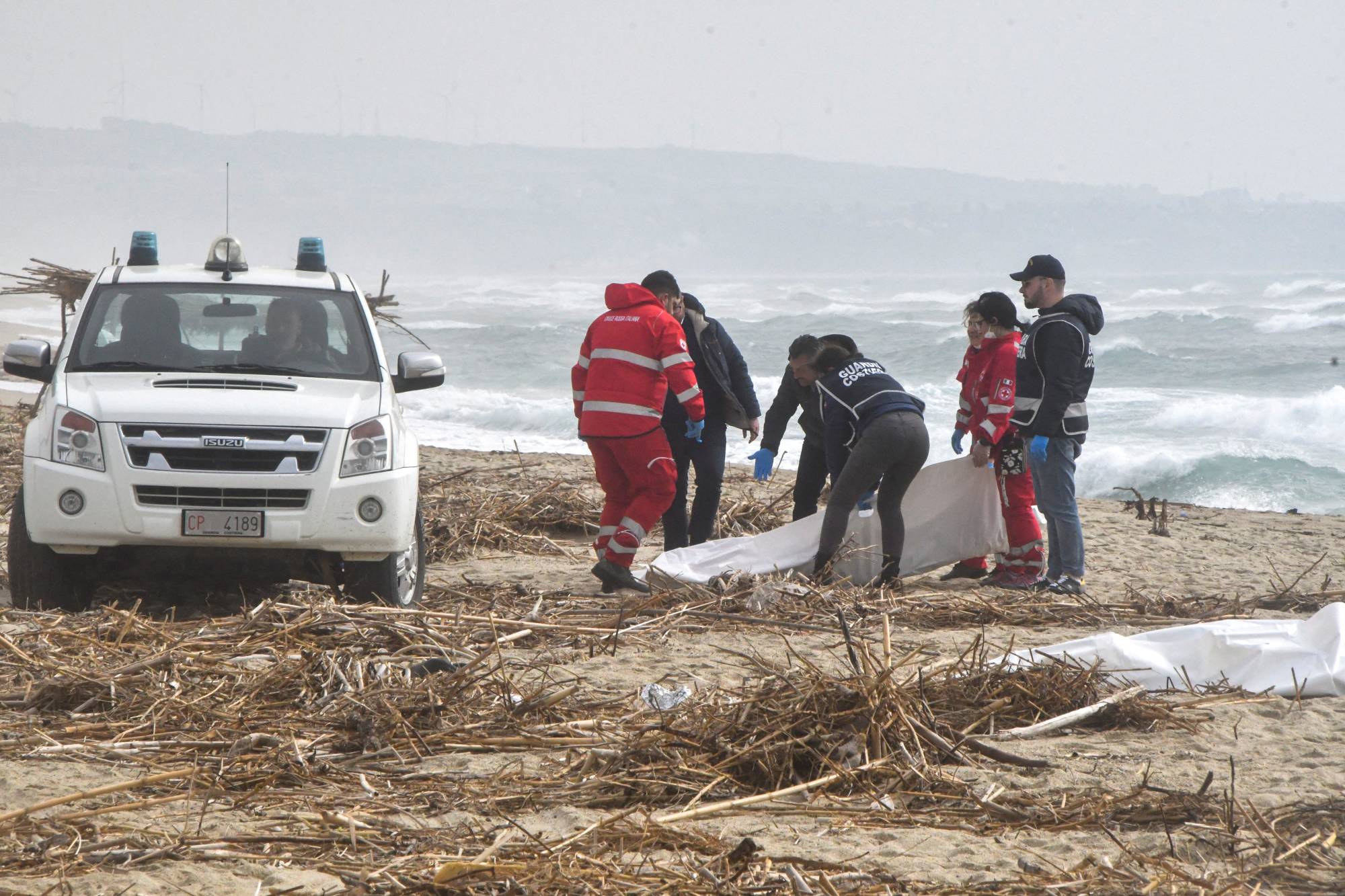 Rescuers recover a body after a suspected migrant boat was wrecked and bodies believed to be of refugees were found in Cutro, the eastern coast of Italy's Calabria region, on Sunday | REUTERS