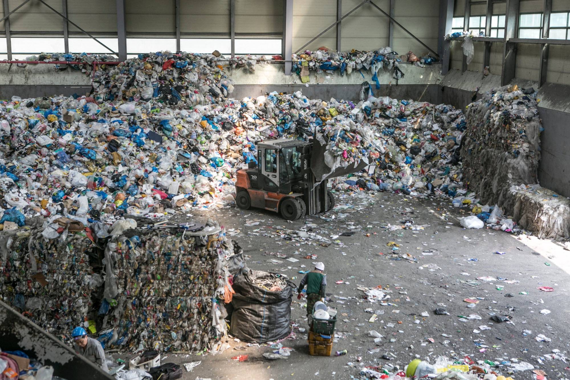 A worker pulls containers of plastic waste at a facility in Gwangmyeong, South Korea, in 2018 | BLOOMBERG