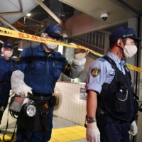 Police officers conduct an investigation at Tokyo Metro\'s Shirokane Takanawa Station, the site of a sulfuric acid attack in August 2021. | KYODO