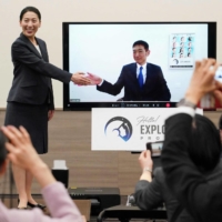 Ayu Yoneda (left) and Makoto Suwa (onscreen) attend a news conference on Tuesday in Tokyo after they officially became astronaut candidates. | AFP-JIJI