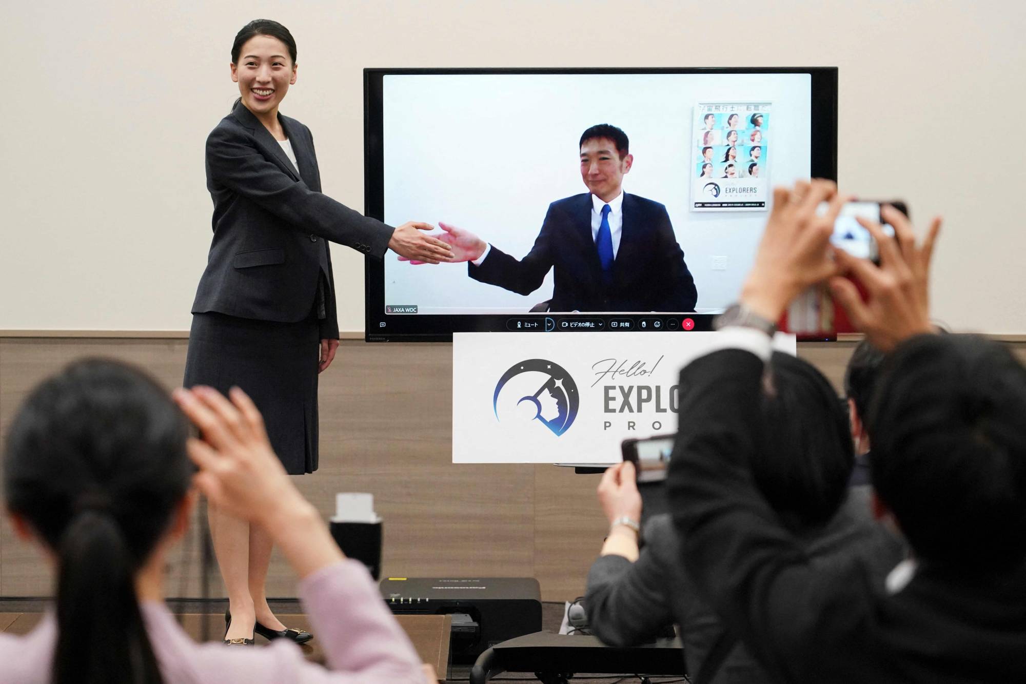 Ayu Yoneda (left) and Makoto Suwa (onscreen) attend a news conference on Tuesday in Tokyo after they officially became astronaut candidates. | AFP-JIJI