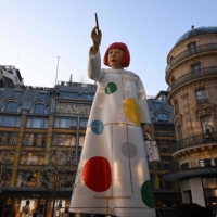 A large statue of contemporary artist Yayoi Kusama pointing a paintbrush at the iconic department store La Samaritaine in Paris.  | AFP-JIJI
