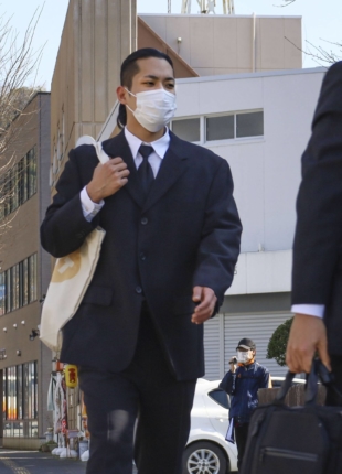 Defendant Sho Taguchi walks to the Yamaguchi District Court on Tuesday. | KYODO