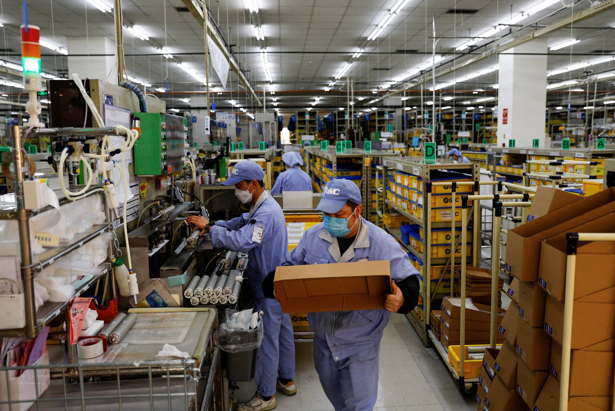Employees work on a production line manufacturing mechanical parts at an SMC factory in Beijing on Jan. 10. China's efforts to ensure its own economic security have come under scrutiny by other global players. | REUTERS