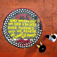 Climate change activists stand by a painted message during a protest outside the headquarters of investment firm BlackRock in San Francisco in October 2021. | REUTERS