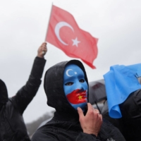 An ethnic Uyghur demonstrator waves a Turkish flag during a protest against China near the Chinese consulate in Istanbul on Feb. 5. | REUTERS