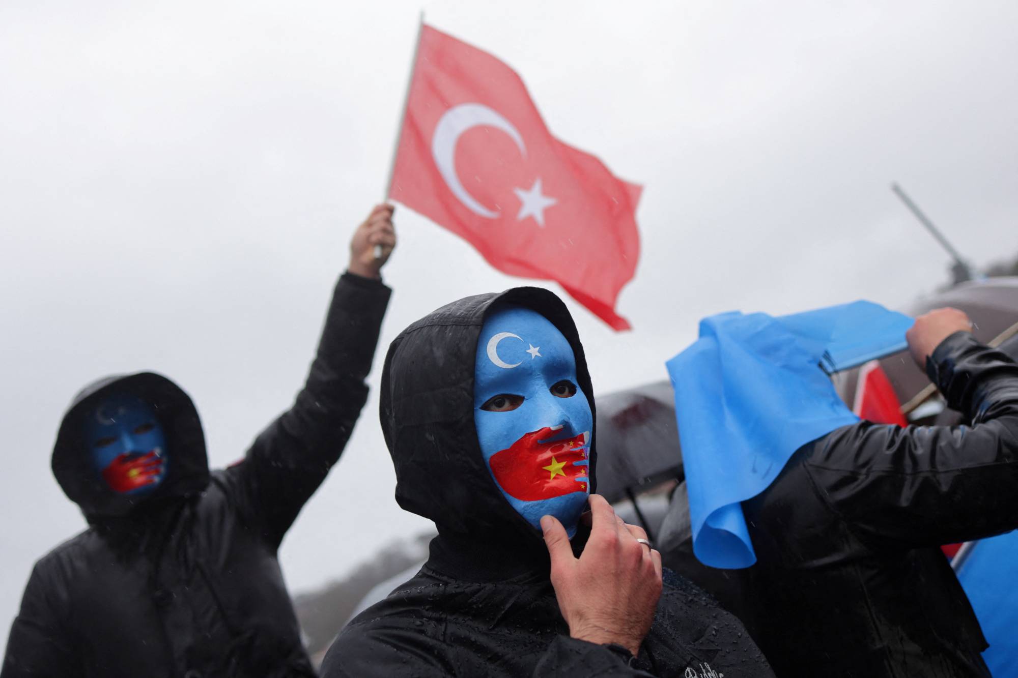 An ethnic Uyghur demonstrator waves a Turkish flag during a protest against China near the Chinese consulate in Istanbul on Feb. 5. | REUTERS