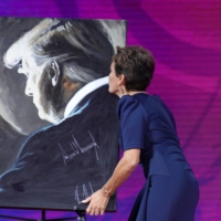 Kari Lake, former candidate for Governor of Arizona, kisses a portrait of Trump after speaking at the CPAC gathering on Friday.  | REUTERS