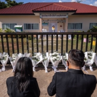 Mourners pray outside the child care center in Thailand where a former police officer killed more than two dozen children in October.  | ANDRE MALERBA / THE NEW YORK TIMES

