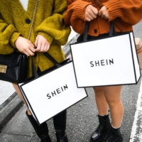 Customers hold Shein bags outside the Shein Tokyo showroom in Tokyo. Fast fashion retailer Shein opened its first ever permanent store in the Harajuku district of Tokyo on Nov. 13. | BLOOMBERG
