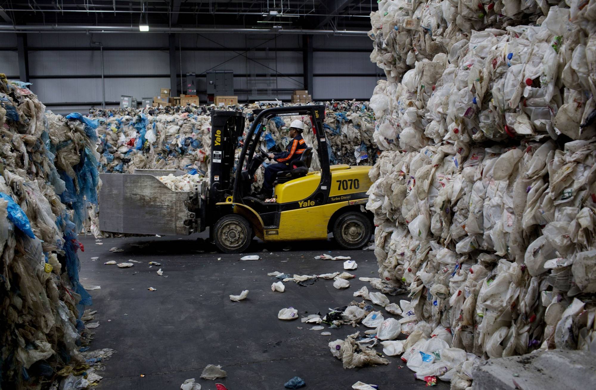 A worker moves bales of plastic bottles for recycling at the Sims Municipal Recycling facility in the Brooklyn borough of New York in 2014. | BLOOMBERG