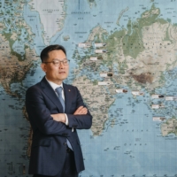 Son Jae-il, CEO of Hanwha Aerospace, at the Hanwha headquarters in Seoul. The white stickers on the map indicate the countries to which Hanwha has successfully exported arms.  | JUN MICHAEL PARK / THE NEW YORK TIMES