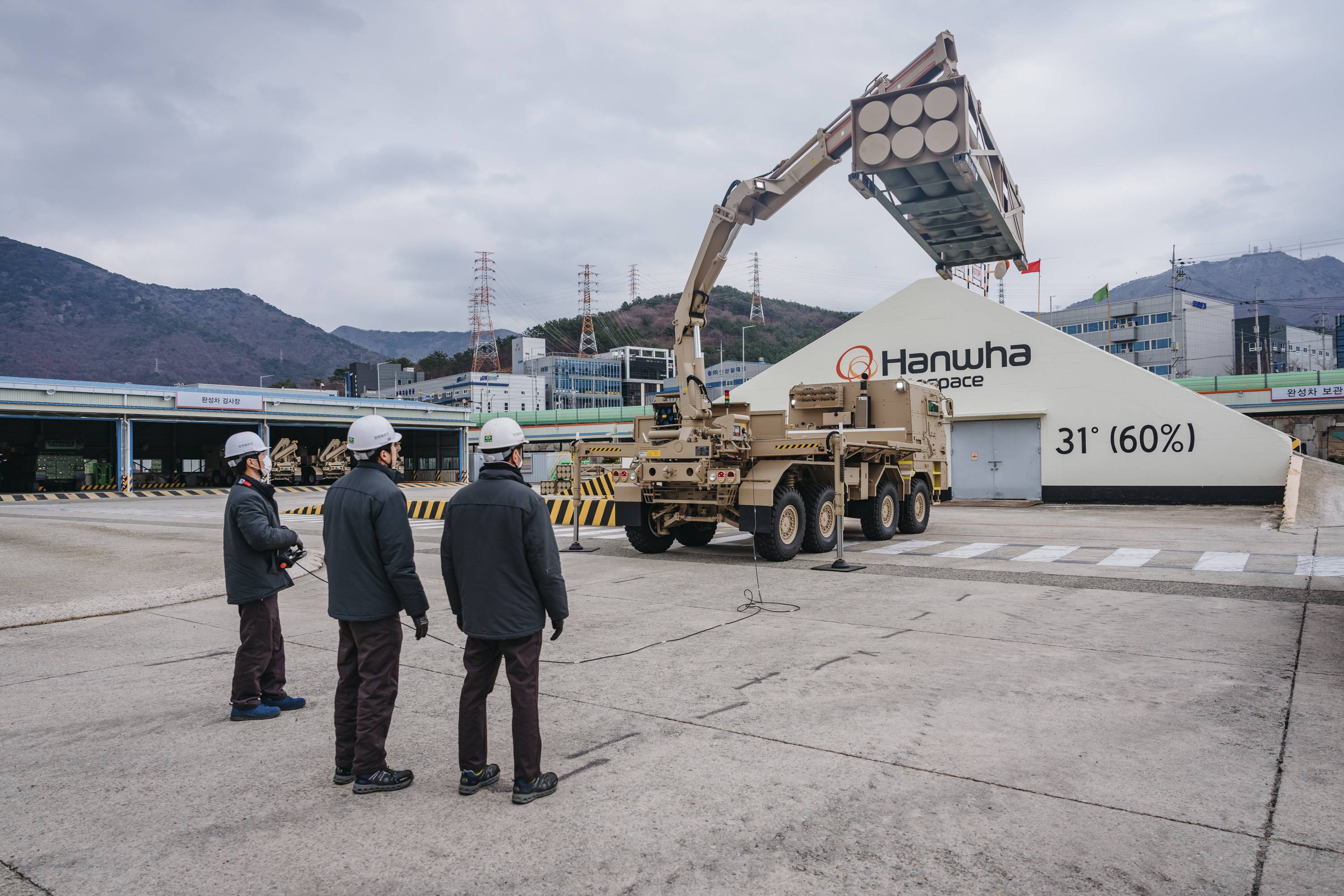 Hanhwa Aerospace engineers look on as a support vehicle unloads a multiple-rocket container during a test run at the factory. | Jun Michael Park / The New York Times
