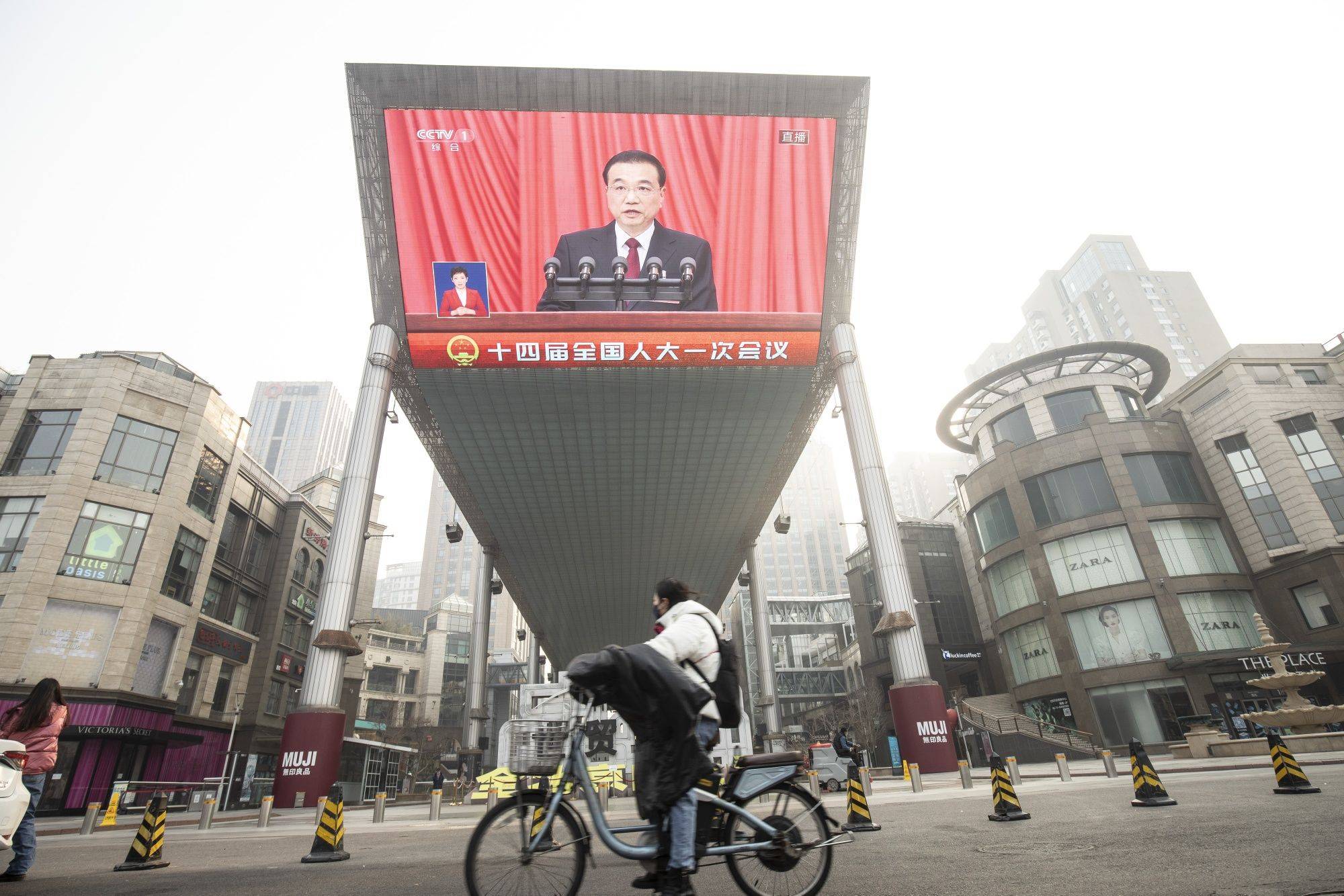 A public screen shows footage of Chinese Premier Li Keqiang addressing delegates at the National People's Congress in Beijing on Sunday. | BLOOMBERG