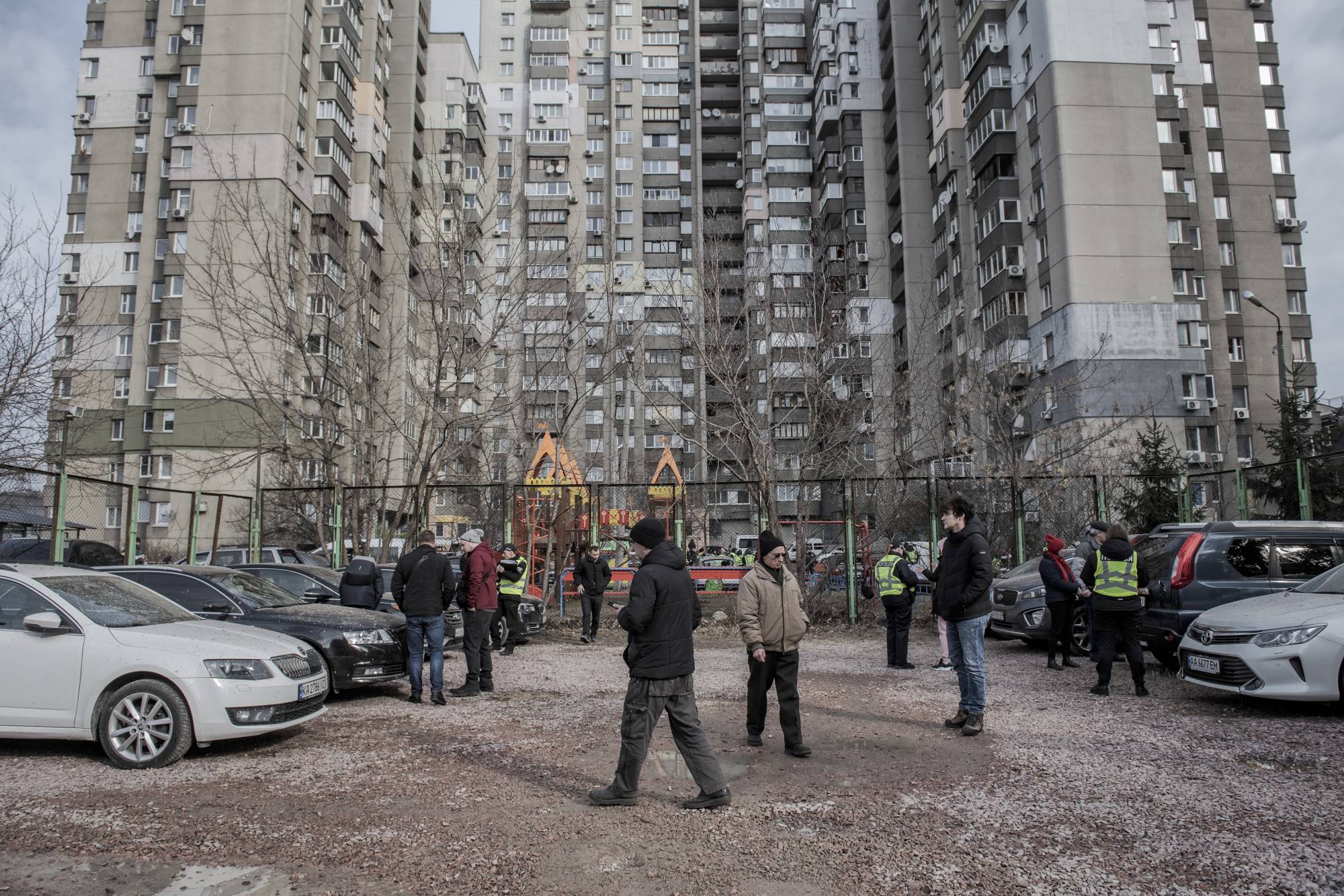Residents and police officers at the scene where missile parts fell onto a residential parking lot and destroyed several cars in the Sviatoshynskyi district of Kyiv on Thursday | LAETITIA VANCON / THE NEW YORK TIMES
