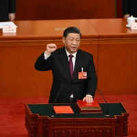 Chinese President Xi Jinping swears under oath after being re-elected as president for a third term during the third plenary session of the National People\'s Congress in Beijing on Friday | AFP-JIJI