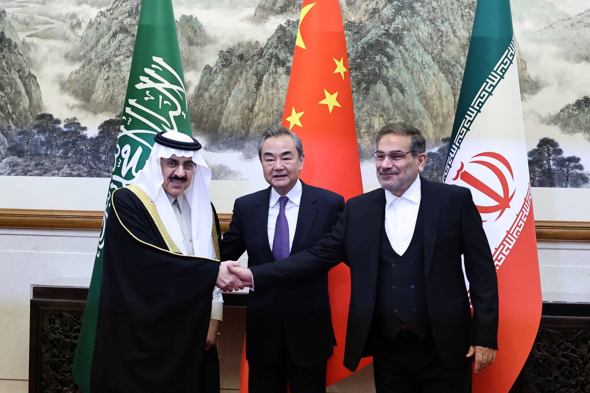 Saudi Arabian Minister of State and national security adviser Musaad bin Mohammed Al Aiban (left) and Ali Shamkhani (right), Iran's Supreme National Security Council secretary, pose for pictures with China's top diplomat, Wang Yi, during a meeting in Beijing on Friday. | CHINA DAILY / VIA REUTERS