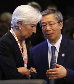 Yi Gang, governor of the People's Bank of China, speaks with Christine Lagarde, managing director of the International Monetary Fund, during a Group of 20 meeting in Fukuoka in June 2019. | POOL / VIA BLOOMBERG
