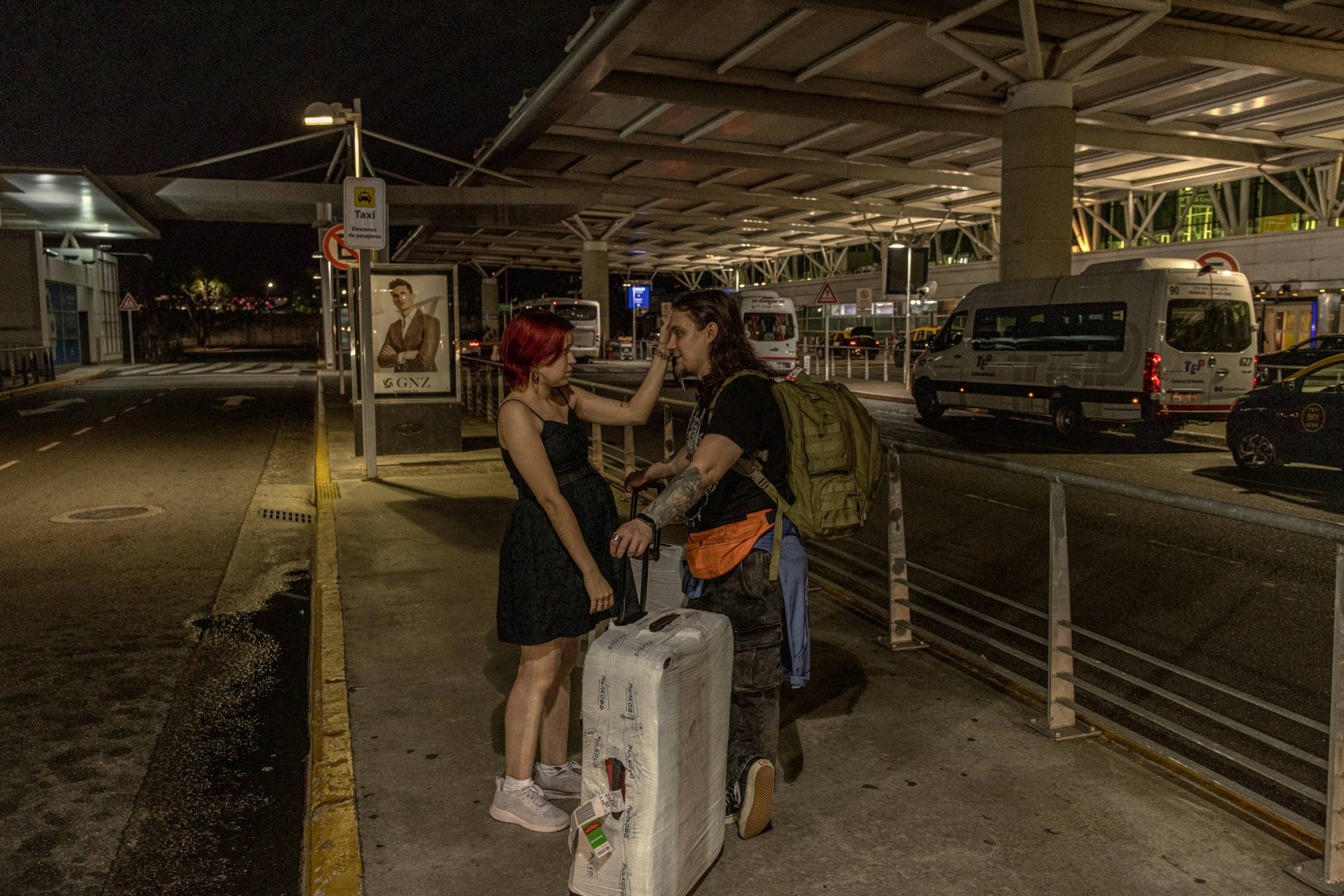 Maria Konovalova greets her husband, Yuriy, who flew in from Russia, at the airport in Buenos Aires. | Sarah Pabst / The New York Times
