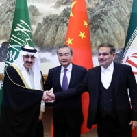 Saudi Arabian Minister of State and national security adviser Musaad bin Mohammed Al Aiban (left) and Ali Shamkhani (right), Iran\'s Supreme National Security Council secretary, pose for pictures with China\'s top diplomat, Wang Yi, during a meeting in Beijing on Friday. | CHINA DAILY / VIA REUTERS 