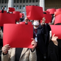 People take part in a protest denouncing a South Korean government plan to resolve a dispute over compensating wartime laborers under Japan’s 1910-1945 colonization of the Korean Peninsula, at the National Assembly in Seoul on Tuesday. | REUTERS