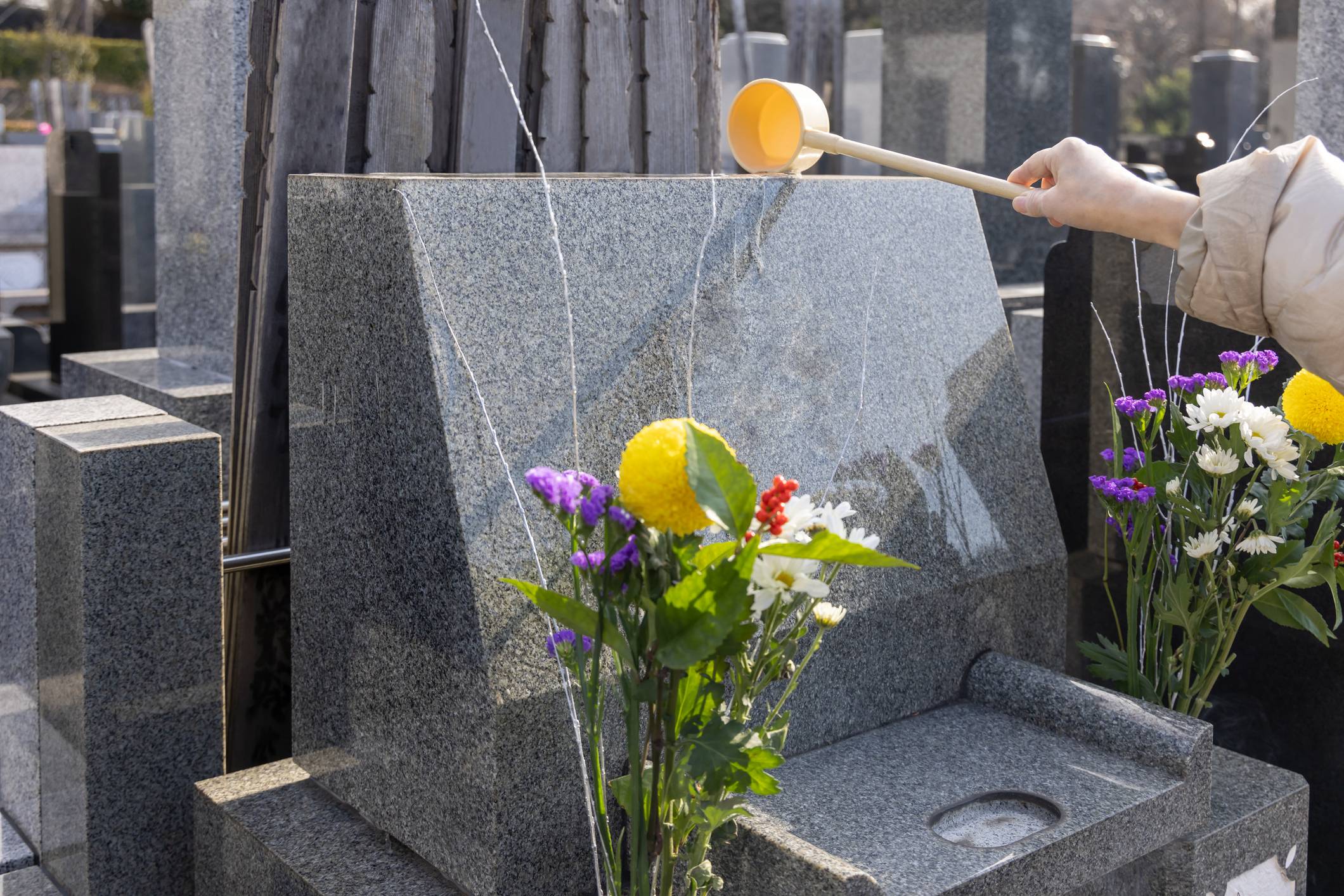 After offerings are made and prayers are said, Japanese family members will pour water over the gravestone in an act of purification. | GETTY IMAGES