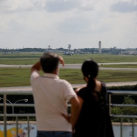 People look toward Kadena Air Base in Okinawa Prefecture from an observation deck in October 2021. The U.S. military has said that the base, which is located in \"Typhoon Alley,\" needs to treat storms \"as a part of the scheduled daily mission.” | REUTERS