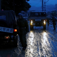 Members and vehicles of the SDF on a disaster relief mission in an area damaged by heavy rain in Asakura, Fukuoka Prefecture, in July 2017. The SDF already makes frequent deployments across Japan and the region in response to floods, landslides, storms and other natural disasters, and these missions are set to increase due to climate change. | REUTERS