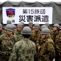 An SDF team gather at Kadena Air Base before heading to mainland Japan to aid earthquake and tsunami victims in March 2011. | U.S. AIR FORCE / VIA REUTERS