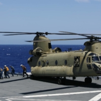 Members of the MSDF unload a patient from a U.S. Army Chinook helicopter in a Humanitarian Assistance and Disaster Relief drill aboard the Ise, south of Oahu, Hawaii, during a multinational military exercise in July 2014. | REUTERS