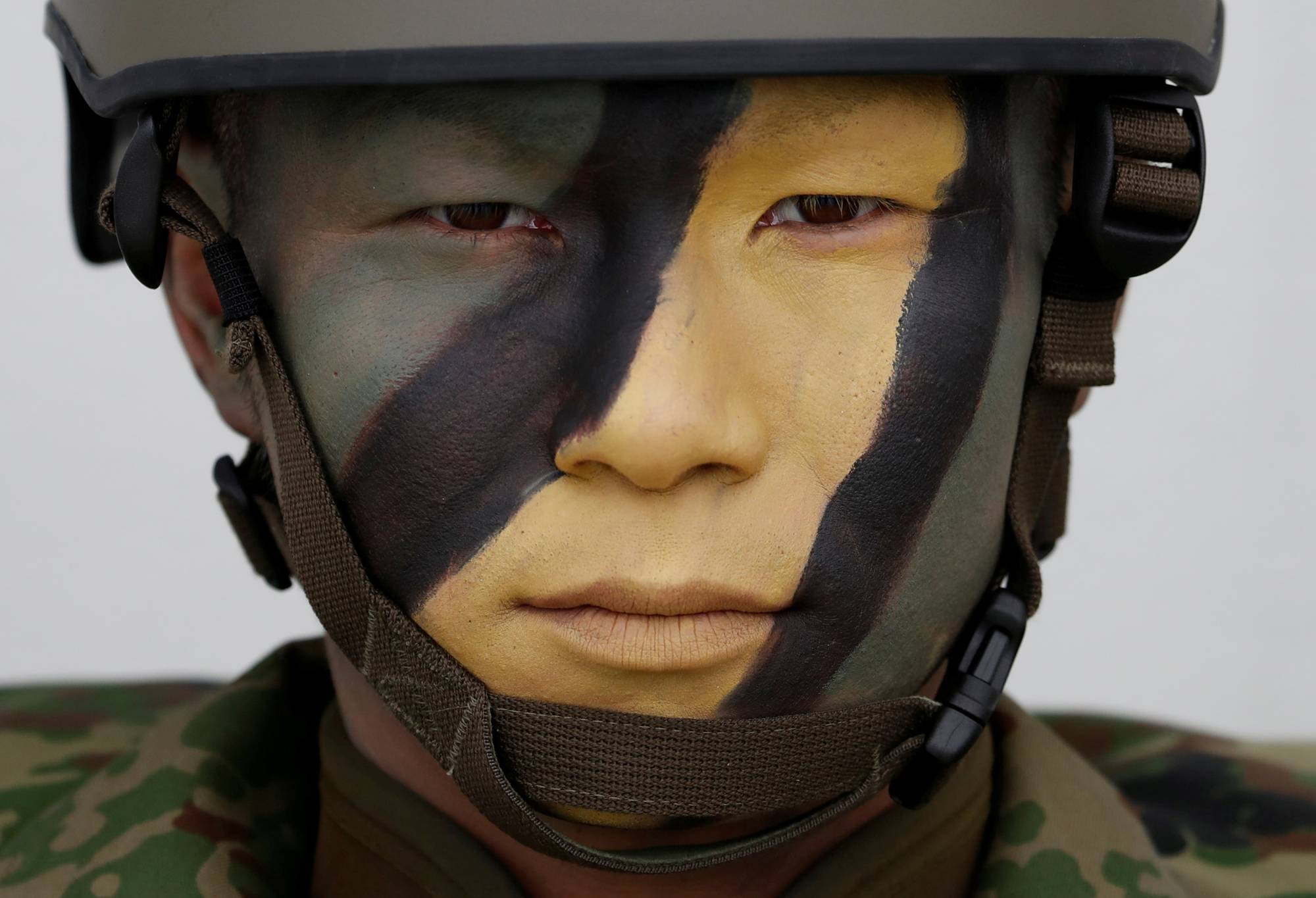 A soldier of the GSDF's Amphibious Rapid Deployment Brigade at the GSDF's Camp Ainoura in Sasebo, Nagasaki Prefecture, in April 2018. SDF and U.S. personnel could face increased health risks due to heat waves or extremely high temperatures exacerbated by climate change. | REUTERS
