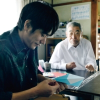 A worker (Kenichi Matsuyama, left) at an elderly care home doles out his own brand of “kindness” to his charges in “Do Unto Others.” | © 2023 ‘DO UNTO OTHERS’ SEISAKU IINKAI
