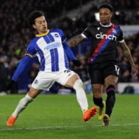 Crystal Palace defender Nathaniel Clyne (right) defends from Brighton\'s Japanese midfielder Kaoru Mitoma during a match at the American Express Community Stadium in Brighton, England, on Wednesday. | AFP-JIJI