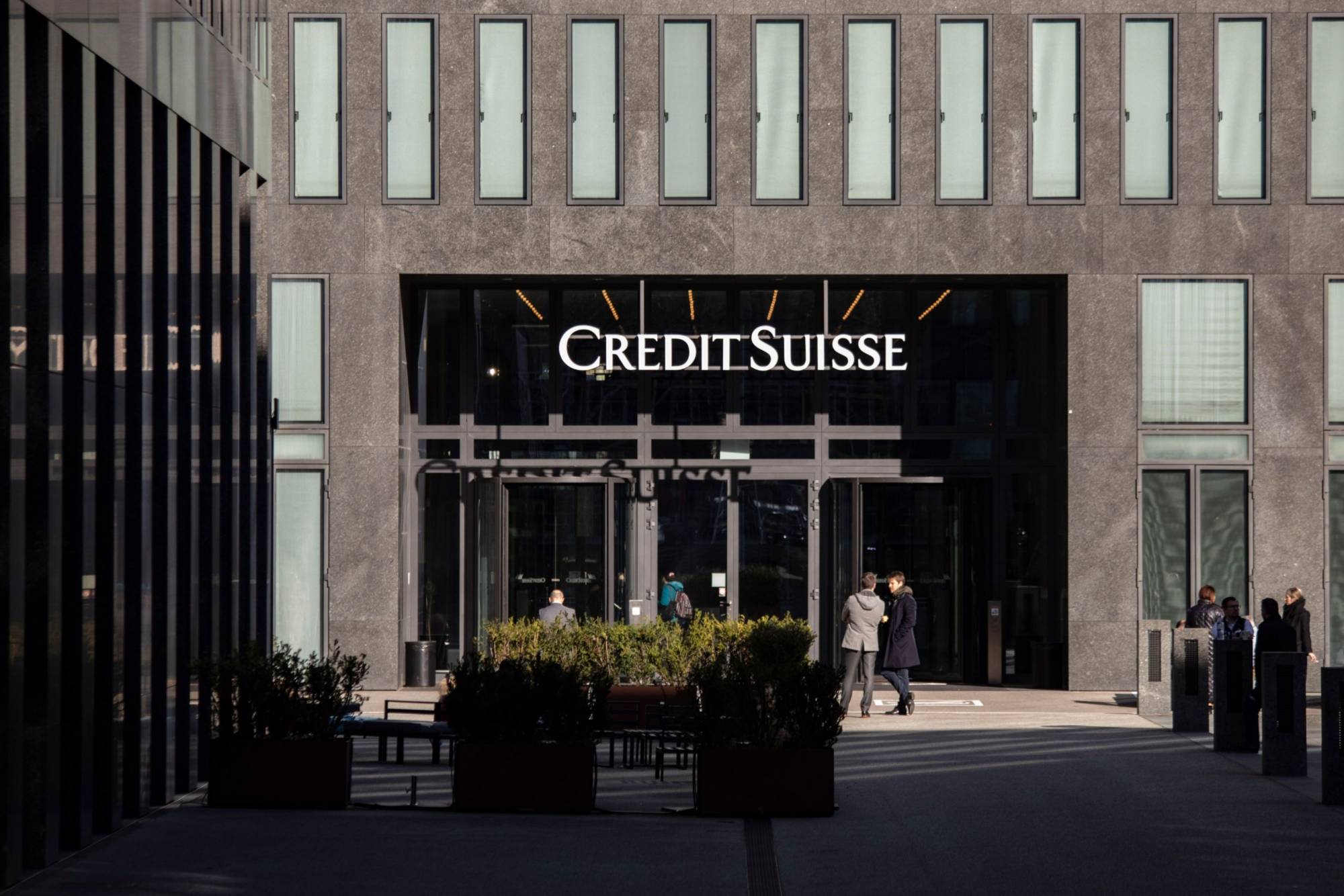 Office workers outside the Credit Suisse Group office tower in Zurich on Thursday | BLOOMBERG