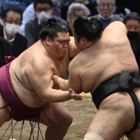 Mitakeumi (left) battles Takakeisho during their bout on the sixth day of the Spring Grand Sumo Tournament in Osaka on Friday. | KYODO