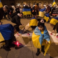 Ukrainians living in the Czech Republic draw lettering in Russian on Saturday reading \'children\' during a rally commemorating people killed a year ago inside the Mariupol Drama Theater building in Ukraine by a Russian air strike. | AFP-JIJI