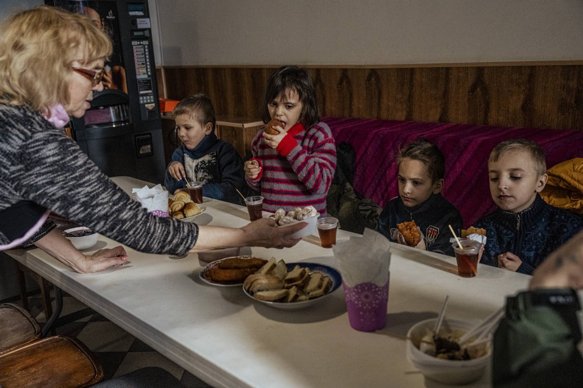 Children evacuated from Kramatorsk because of heavy shelling near their home eat a meal provided by a nongovernmental organization in Pokrovsk, Ukraine, on March 1. | Daniel Berehulak / The New York Times