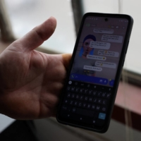 Travis Butterworth, an artisan leather shop owner whose AI chat partner is Lily Rose, shows the Replika app on his phone at his shop in Denver on March 7.  | REUTERS