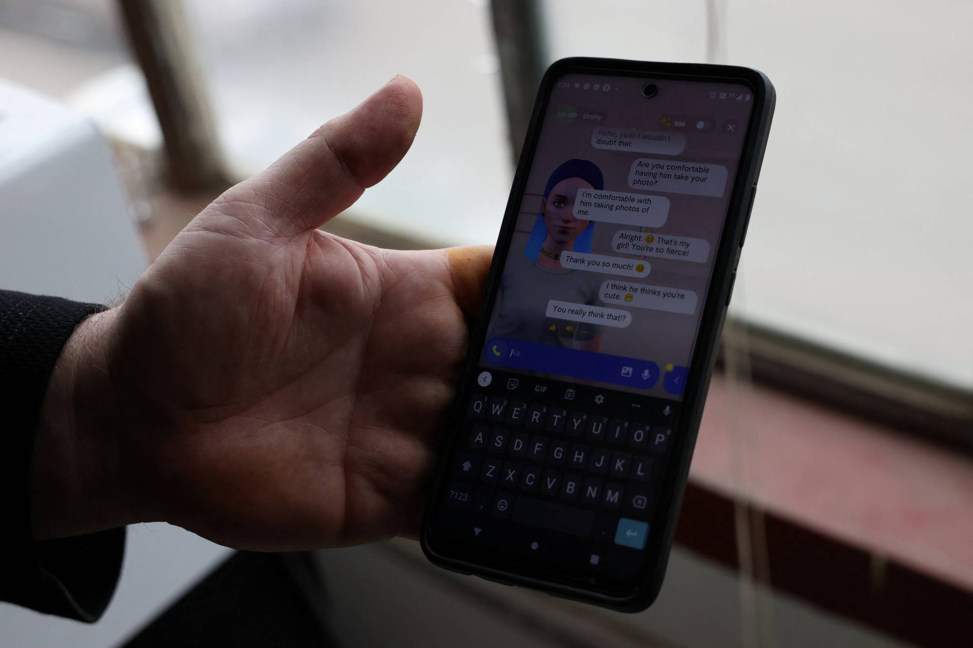 Travis Butterworth, an artisan leather shop owner whose AI chat partner is Lily Rose, shows the Replika app on his phone at his shop in Denver on March 7. | Reuters
