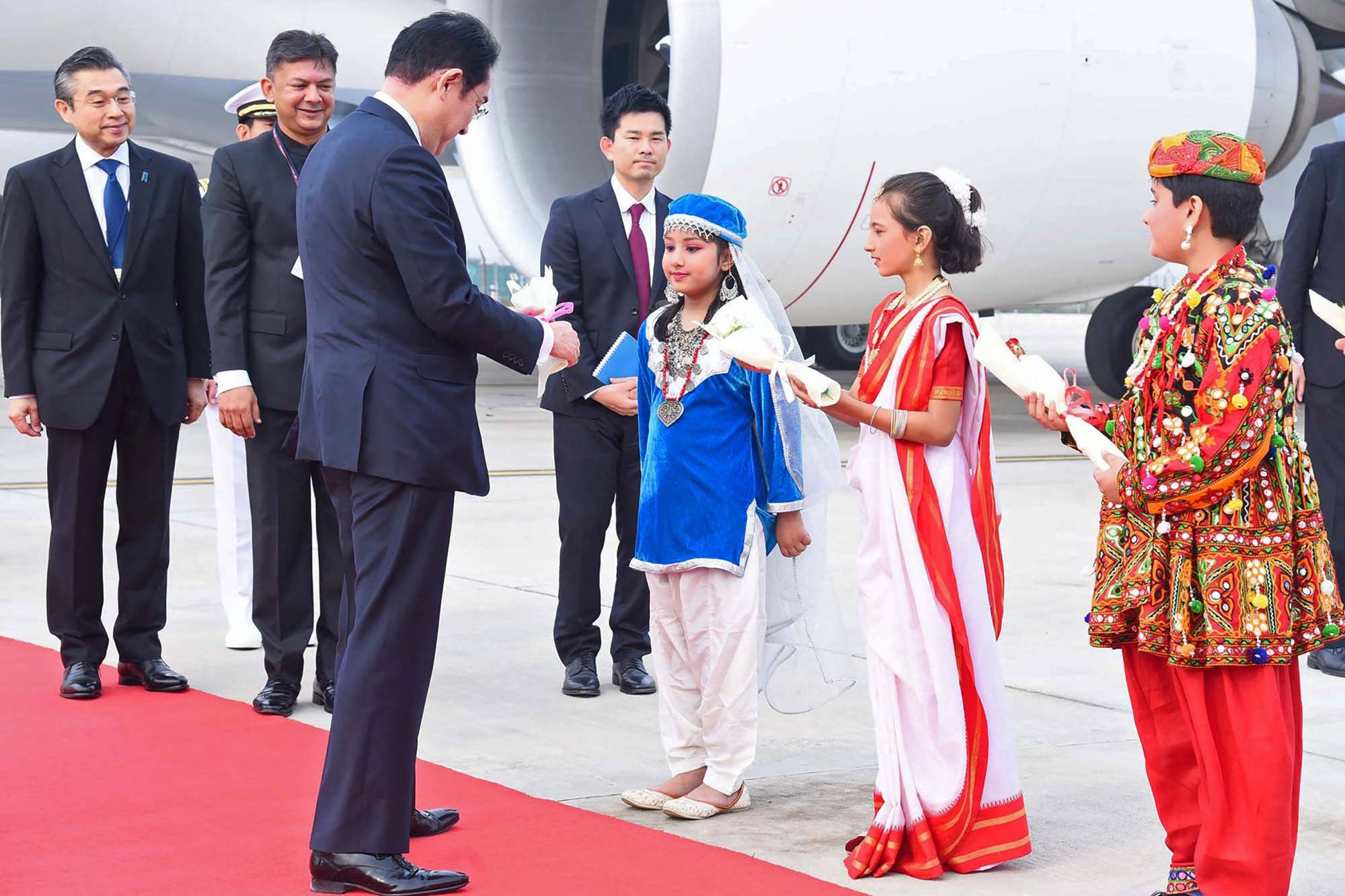 Kishida is greeted by traditionally dressed Indian children upon his arrival at the airport in New Delhi on Monday. | Indian Press Information Bureau / via AFP-JIJI