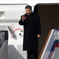 Chinese President Xi Jinping waves as he disembarks from his aircraft upon arrival at Moscow\'s Vnukovo airport on Monday | KOMMERSANT PHOTO / VIA AFP-JIJI