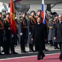 Xi, accompanied by Russian Deputy Prime Minister Dmitry Chernyshenko, walks past an honor guard during a welcoming ceremony at Moscow\'s Vnukovo airport on Monday. | KOMMERSANT PHOTO / VIA AFP-JIJI
